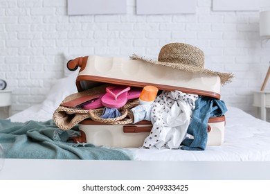 Packed suitcase with belongings on bed. Travel concept - Powered by Shutterstock