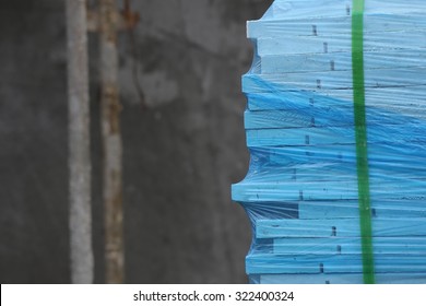 Packed Tiles. Stack Of White Wall Covering Tiles Packed With Blue Transparent Shrink Wrap In A Construction Site.