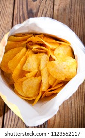 Packet Of Chips On Wooden Table. Food Background. Potato Chips.Top View. Mock Up. Copy Space.Template. Blank.