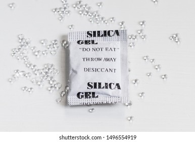 Packet Of Silica Gel And Beads On A White Table Surface