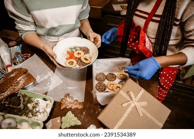 Packing cookies for gift on Christmas and New Year. Preparing food donation for Winter holidays