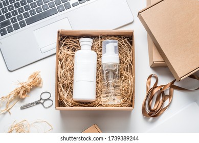 Packing cosmetic, shampoo bottles on cardboard box