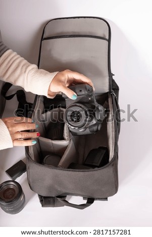 Packing a digital camera into a camera bag before a photography session