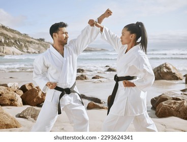 Packing power into their punches. Shot of two young martial artists practicing karate on the beach. - Powered by Shutterstock