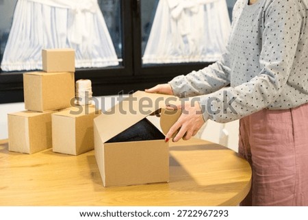 Packing a product for a return process in a minimalist cardboard box.