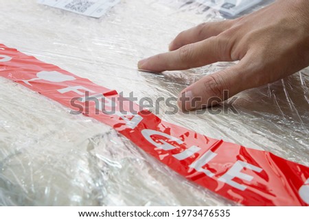 packing shipping box of goods with fragile sticker
