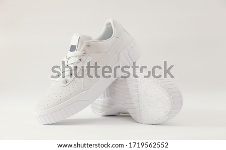 A packshot photography of light-grey sneakers isolated on white background