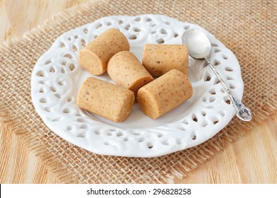 Pacoca - brazilian candy of ground peanut with wicker hat of festivity festa junina decoration. Selective focus