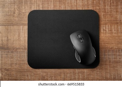 Pad With Computer Mouse On Wooden Table