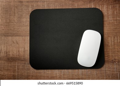 Pad With Computer Mouse On Wooden Table