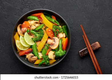 Pad Pak Ruam Or Veg Thai Stir-Fried Vegetables In Black Bowl On Dark Slate Backdrop. Pad Pak Is Thailand Cuisine Vegetarian Dish With Mix Of Vegetables And Sauces. Thai Food. Top View