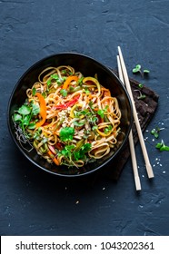 Pad Thai vegetarian vegetables udon noodles in a dark background, top view. Vegetarian food in asian style. Copy space