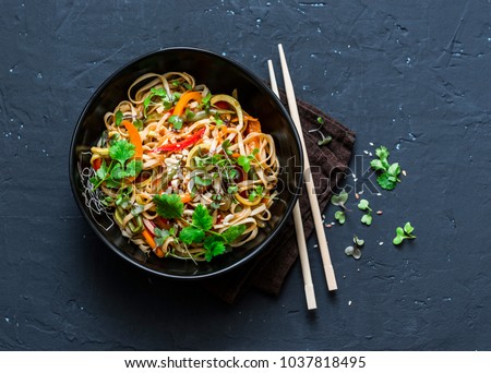 Pad Thai vegetarian vegetables udon noodles in a dark background, top view. Vegetarian food in asian style. Copy space 