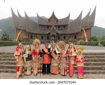 Padang, Indonesia- September 13th, 2021 :Group of people wearing Minang traditional clothes, West Sumatra with complete accessories.  They are in front of the palace of the Baso Rumah Gadang Padang.
