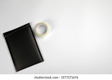 Padded Envelope With Bubble Wrap And Tape On Light Background, Flat Lay. Space For Text