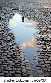 Paddle on cobblestones with reflection of clouds and a tower of the Freiburger minster