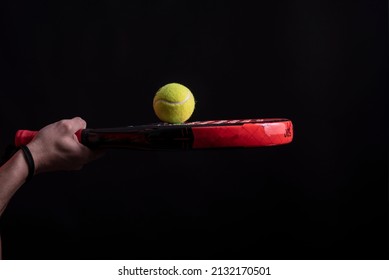 A paddle tennis ball on racket in studio shot