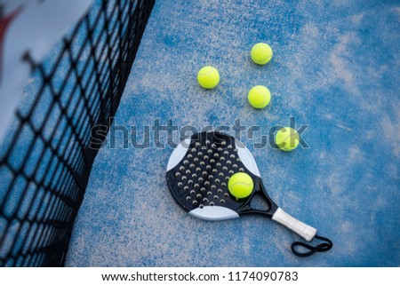  Paddle tennis racket and balls on court artificial grass
