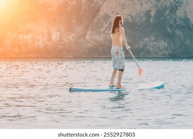 Paddleboarding Sunset Ocean Man - A man paddleboards in calm ocean waters at sunset with a mountain in the background. - Powered by Shutterstock