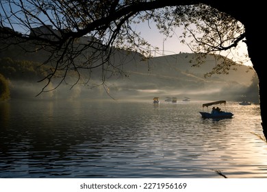 Paddleboats on the lake with haze at sunset. Leisure time activity or holidays concept photo.