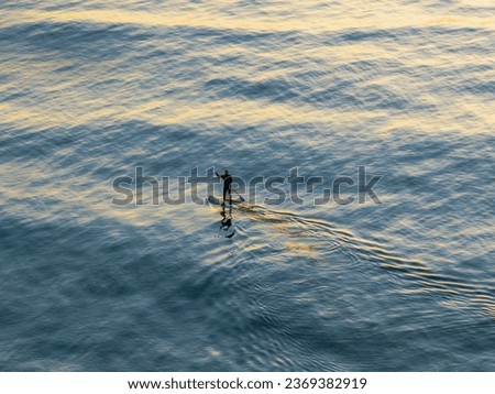 Similar – Ein Shortboard Sportler geht vom Strand auf das wellige Meer um zu Surfen. Blick von der Seite