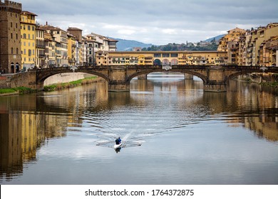 paddling on the Arno river in Florence with medieval stone bridge Ponte Vecchio on background. Tuscany, Italy