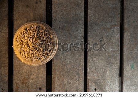 Paddy rice or nellu in ancient traditional bowl named Para,kerala Traditional nirapara,a Grain Measuring Bowl, Ancient Measuring Vessel known as para,Changazhi and Nazhi,top view in a woodenbackground