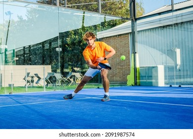 Padel match in a blue grass padel court - Handsome boy player playing a match - Shutterstock ID 2091987574
