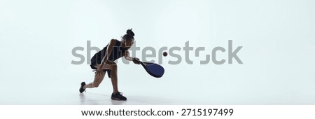 Padel player bends forward controlling ball close to floor. Concept of padel precision, technical play and promotional visuals for professional sport advertising. Banner