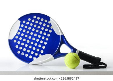 Padel racket and ball reflected on white table and white isolated background. Front view.