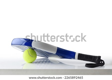 Padel racket on ball reflected on white table and white isolated background. Front view.