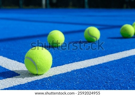 padel tennis balls in a blue paddle tennis court, background for racket sports concept