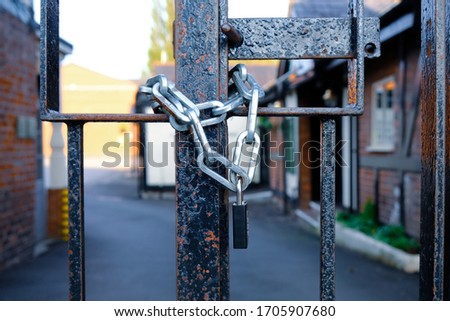 Padlock and chain around a metal gate. Keep out. Do not enter. Security