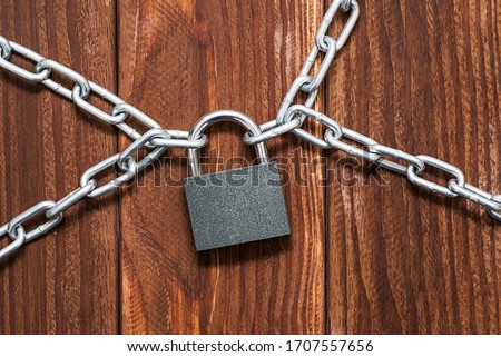 Padlock and chain on wooden background. Metal chain and locked padlock on wooden background. Safety concept.