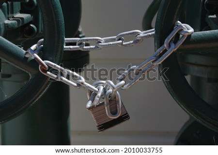 Padlock and heavy chain locking main water valves