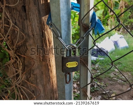 Padlock lock up with chains attach to the metal fences and door.