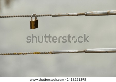 Padlock locked in a bridge wire as a live symbol