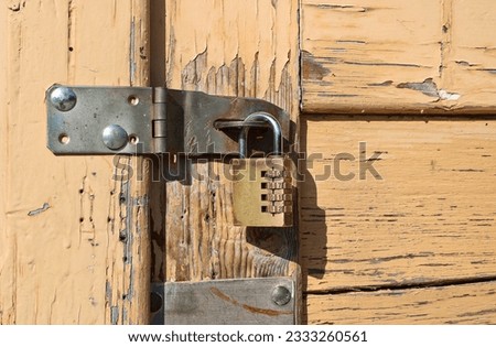 Padlock with numeric code with hasp on old chipped door