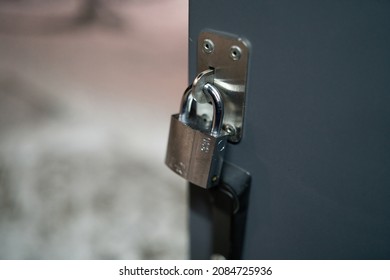Padlock on gate of small gray container closeup . High quality photo