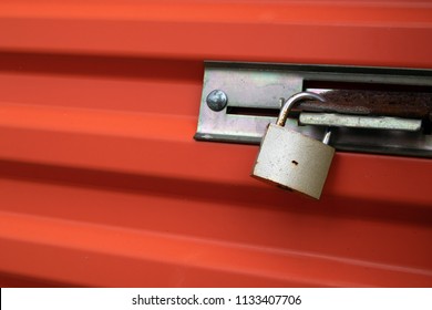 Padlock On An Orange Self Storage Unit Door.