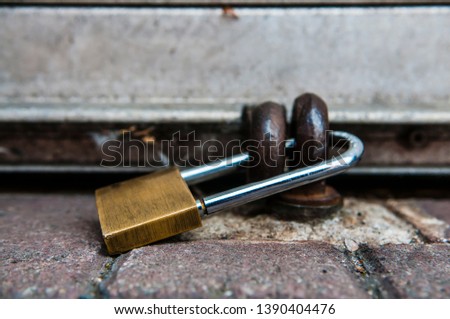 Padlock securing the shutter of a shop.