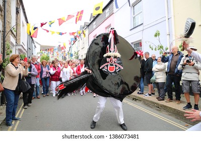 Padstow, Cornwall, UK. May 01, 2019. A large crowd clears to make way for the Obby Oss (hobby horse) of Padstow as it makes its way through the town during the May Day celebrations.