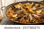 Paella Valenciana: Traditional Spanish paella featuring saffron rice, chicken, rabbit, and fresh vegetables, cooked to perfection for a flavorful and satisfying meal.






