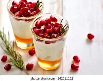 Pafait or yogurt with honey and juicy pomegranate seeds decorated with rosemary - Powered by Shutterstock