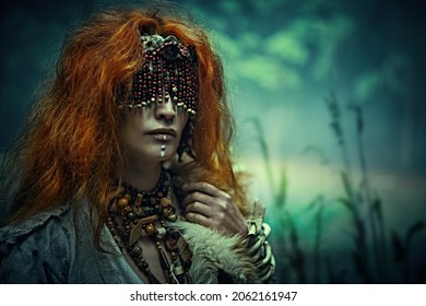 Paganism. Red-haired Druid Woman With A Mask On Eyes Stands In A Forest Trying To Awaken Her Spiritual Vision. Halloween. Copy Space.