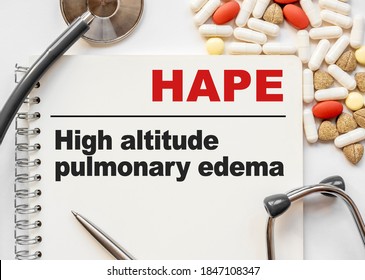 Page In Notebook With HAPE High Altitude Pulmonary Edema On White Background With Stethoscope And Group Of Pill. Medical Concept. Term And Abbreviation