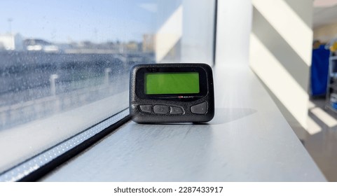 Pager is a small wireless device that receives and displays numeric or text messages, symbolizing the era of technological advancements in communication and transition from analog to digital device