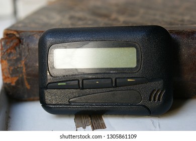 Pagers, Old Vintage Beeper. Pager On The Antique Book