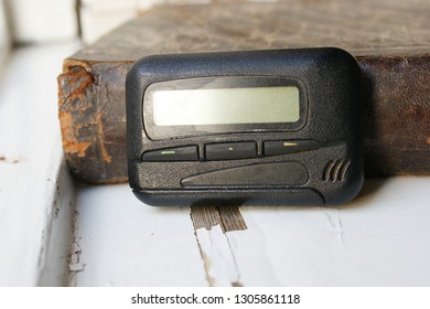 Pagers, Old Vintage Beeper. Pager On The Antique Book