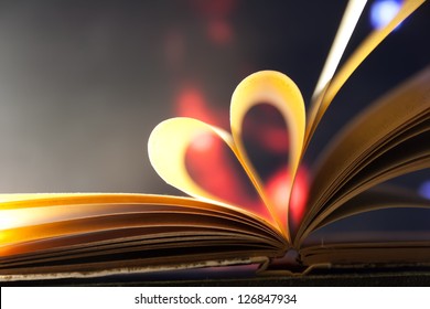 Pages of a book curved into a heart shape.